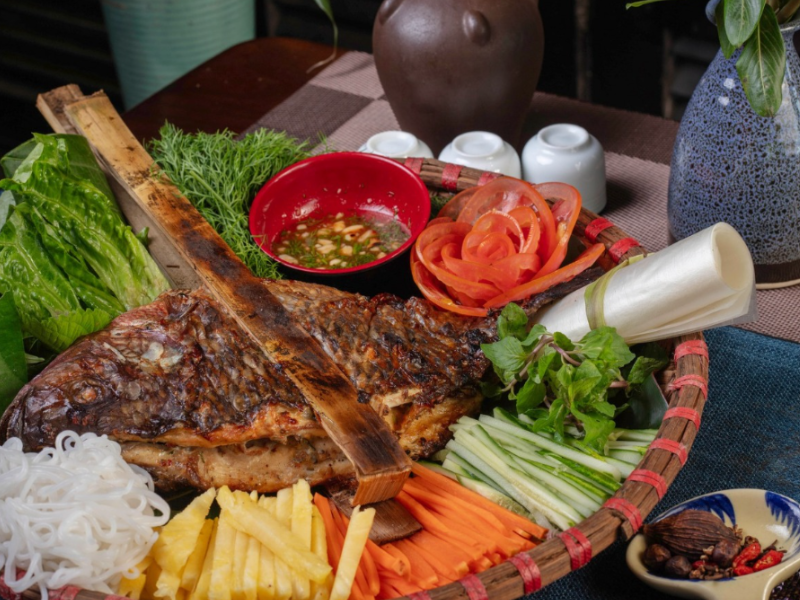 Cá được kẹp thanh tre già, nướng chậm trên than củi để giữ trọn vị ngọt thanh.